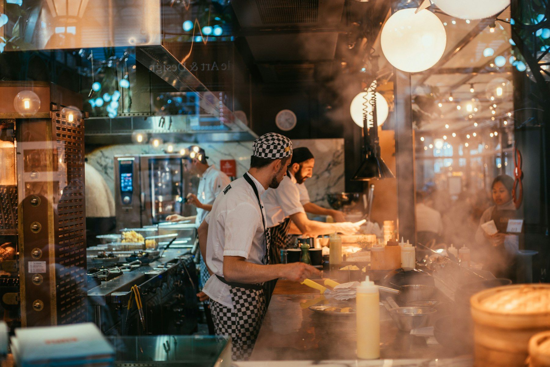 Cuisine ouverte en plein service, cuisiniers au travail derrière le comptoir